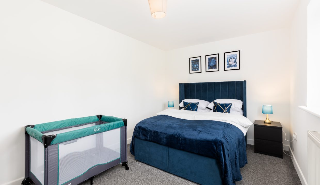 Blue bedroom with travel cot
